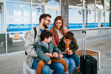 Happy ypung family with luggage in railroad station go together on vacation.