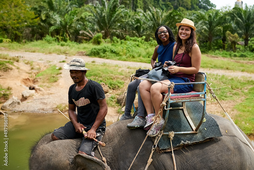 The views are so beautiful from up here. Portrait of young tourists on an elephant ride through a tropical rainforest.