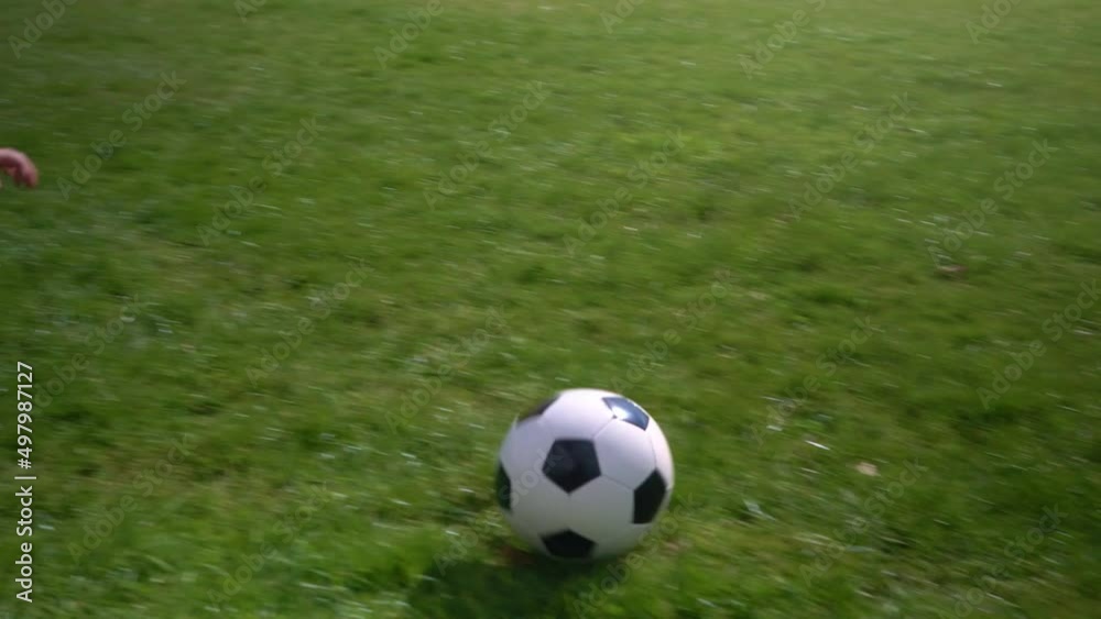Happy Family Of Children Having Fun In Spring Park. Little Kid Run. Child Boy Dribbles Black White Classic Soccer Ball On Green Grass. People Playing Football. Childhood, Sport, Championship Concept Happy Family Of Children Having Fun In Spring Park. Little Kid Run. Child Boy Dribbles Black White Classic Soccer Ball On Green Grass. People Playing Football. Childhood, Sport, Championship Concept