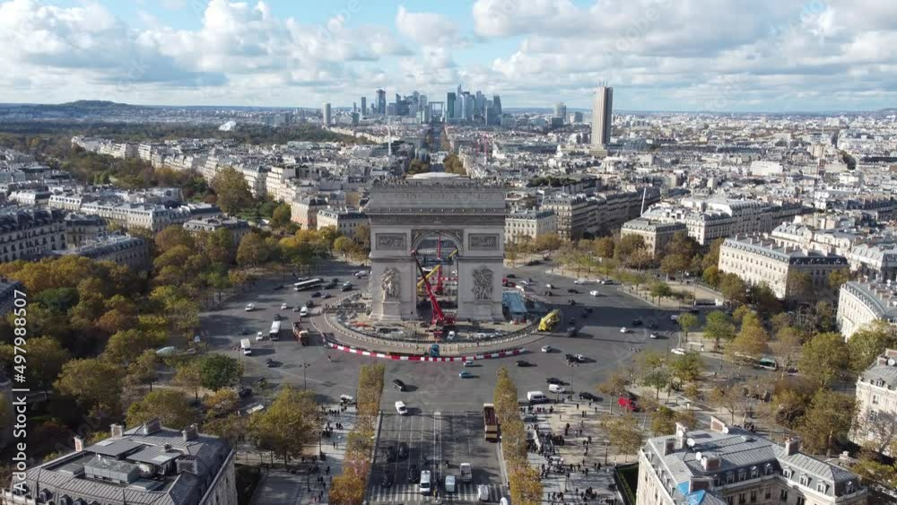 Drone view of the Arc de Triomphe with skyscrapers in the background.