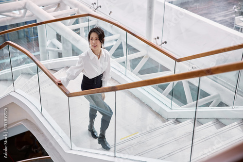 Asian business woman walking up the stairs.