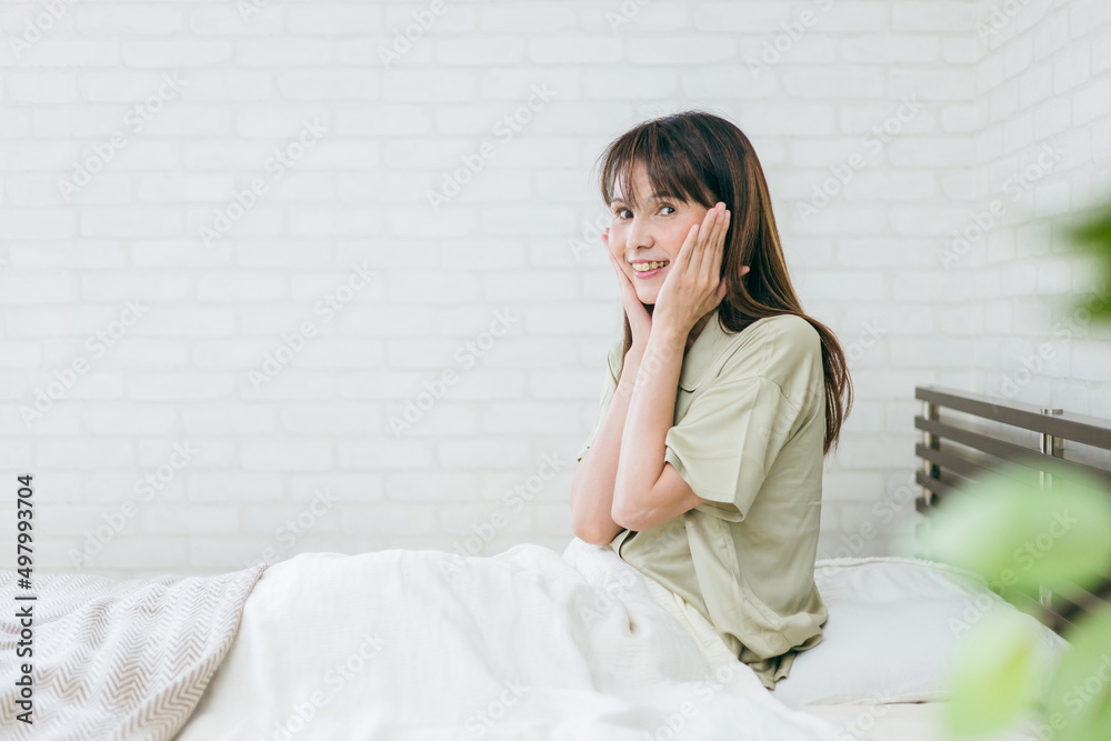 ベッドでお肌を触るミドル世代の女性(笑顔)
ベッドでお肌を触るミドル世代の女性(笑顔)