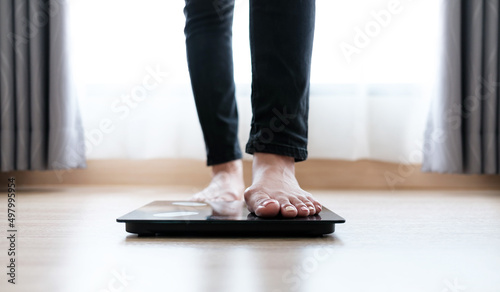 Woman's feet weighing on scales. weight loss, self care and body Concept. © Ton Photographer4289