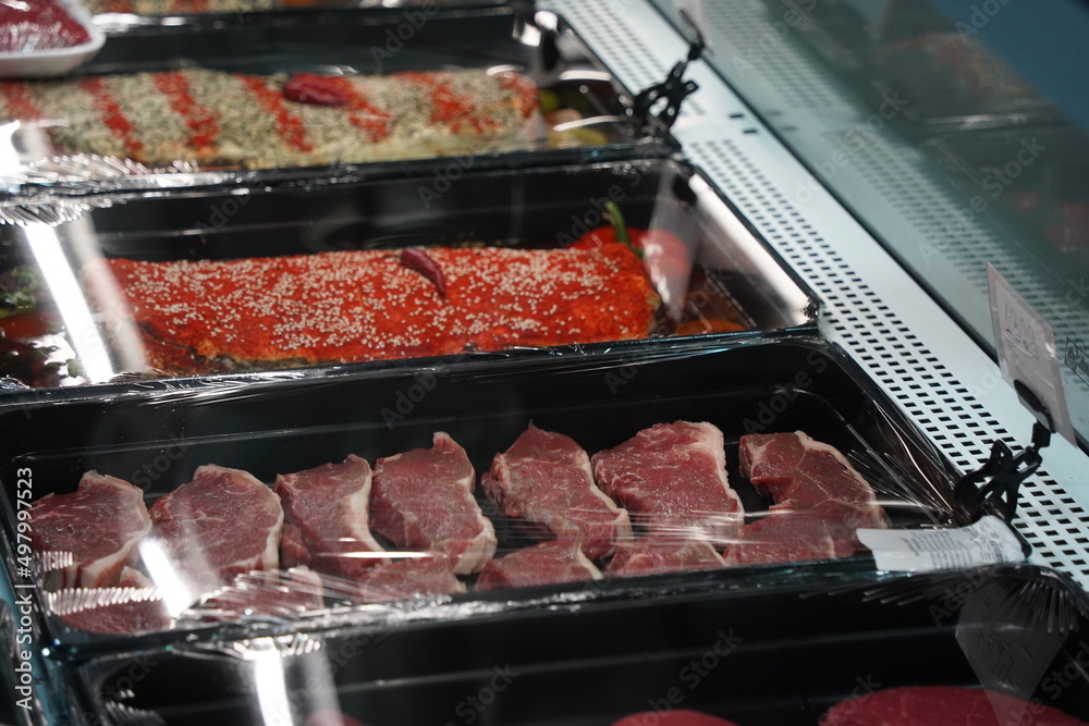 Almaty, Kazakhstan - 12.23.2021 : A row with chilled meat of various kinds in the refrigerators of the hypermarket. Almaty, Kazakhstan - 12.23.2021 : A row with chilled meat of various kinds in the refrigerators of the hypermarket.