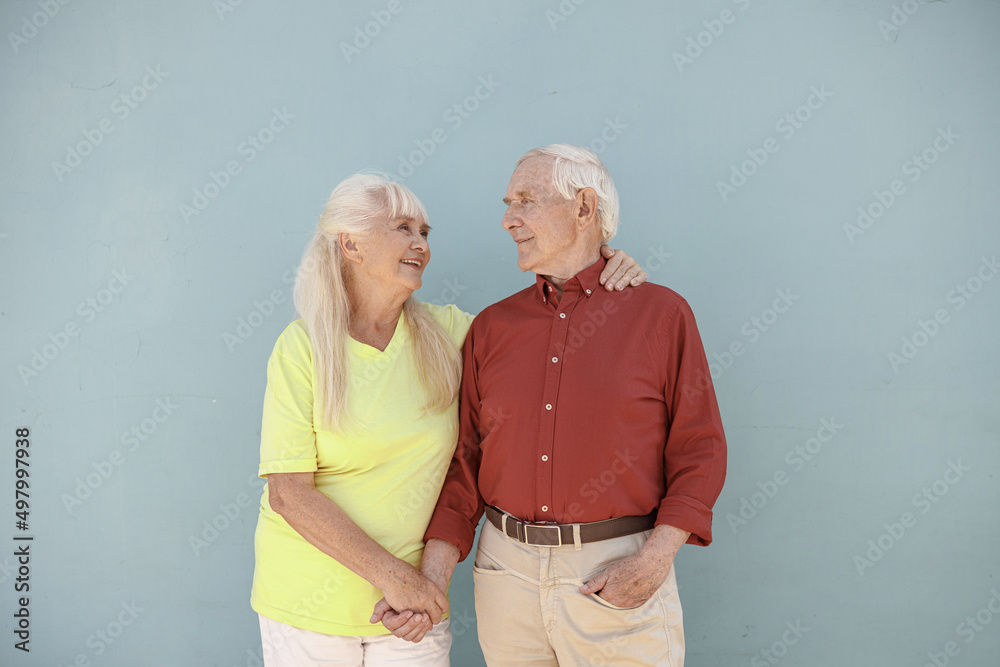 Happy positive senior woman and loving man hug on light grey background Happy positive senior woman and loving man hug on light grey background