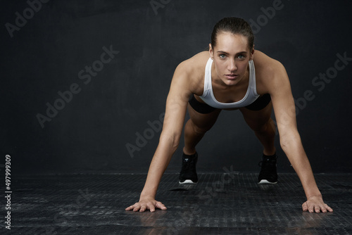 Its time to get ripped. Studio portrait of an attractive young woman working out against a dark background.
