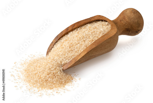 Raw psyllium husk in the wooden scoop, isolated on white background. photo