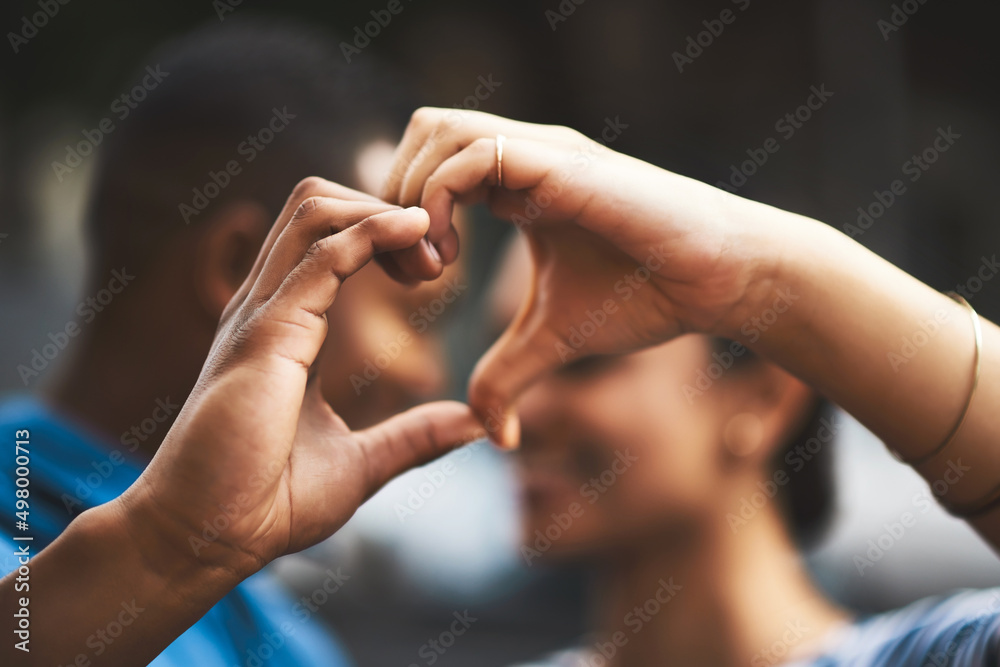 My heart will always be yours. Cropped shot of a young couple making a heart gesture with their hands outdoors.
