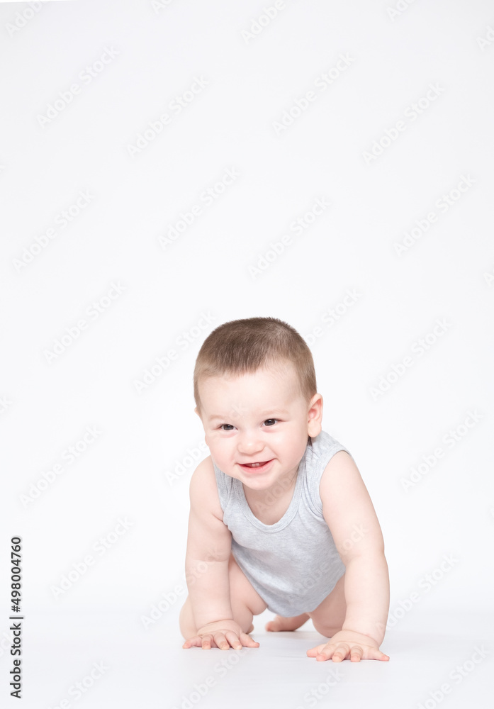 eight month old baby boy crowling on the ground and looking at camera eight month old baby boy crowling on the ground and looking at camera