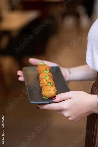 chicken croquette in hand and having with shop stick