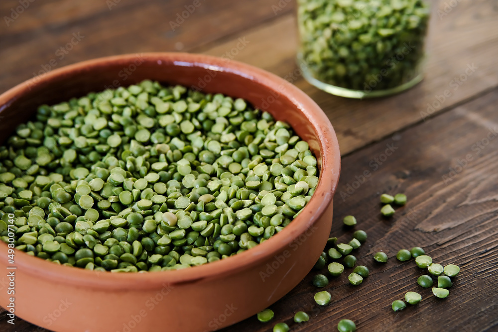 Dry green peas in a bowl. Split green peas. Peas on a wooden background. Side view. Lettering green dry peas. Dry green peas in a bowl. Split green peas. Peas on a wooden background. Side view. Lettering green dry peas.
