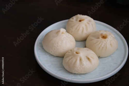 close up a plate of Chinese pan-fried pork buns  Sheng Jian Bao  on table. Traditional food 