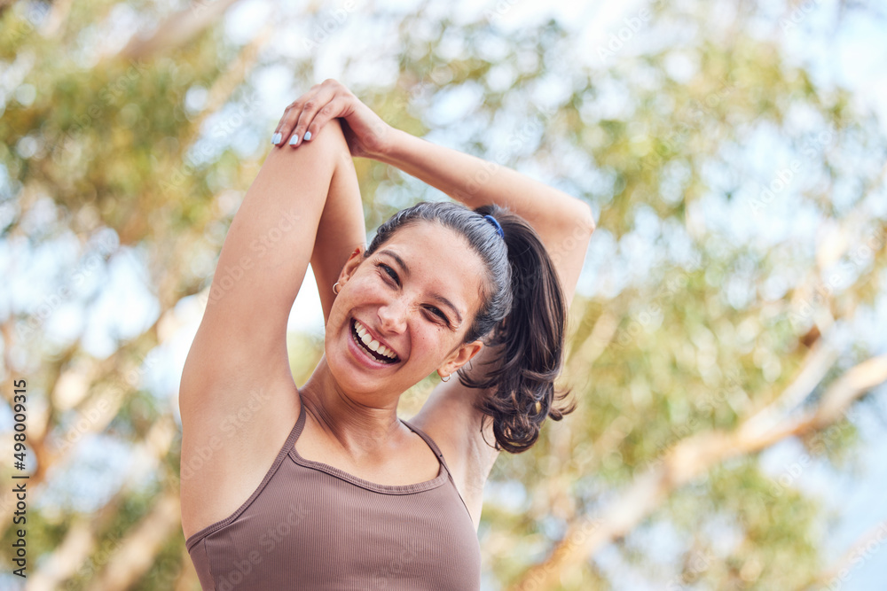 Good morning, time to stretch. Portrait of a sporty young woman stretching her arms while exercising outdoors.