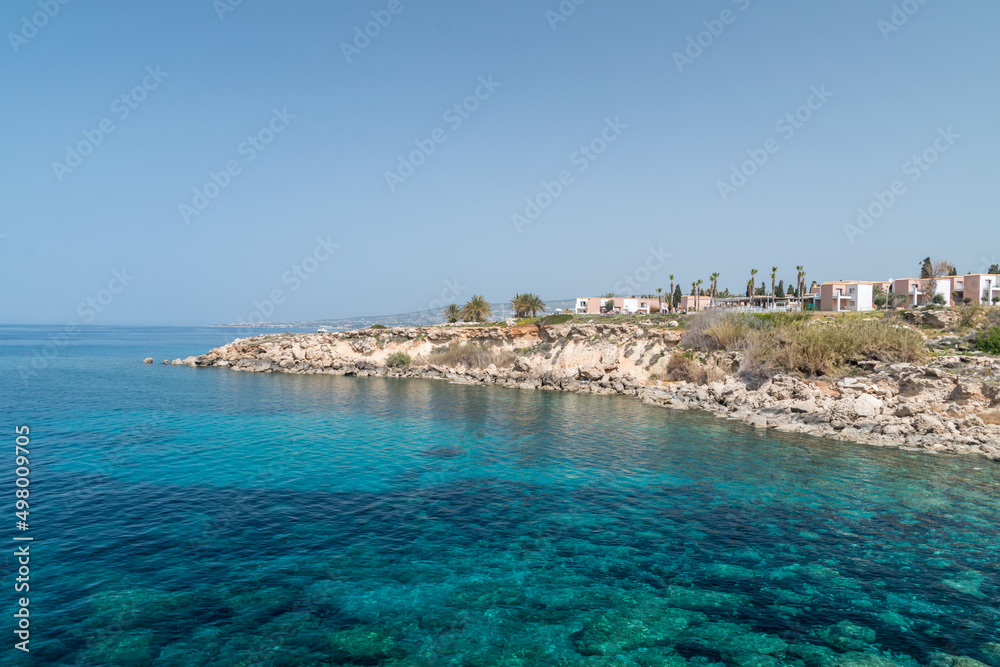 Rocky coastline with clear beautiful blue water on Mediterranean sea. Seashore on Chloraka, Cyprus.