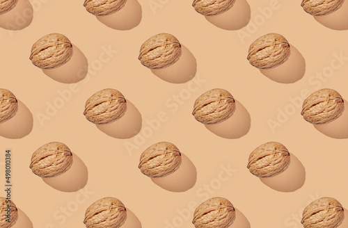 Pattern of walnuts on brown pastel background