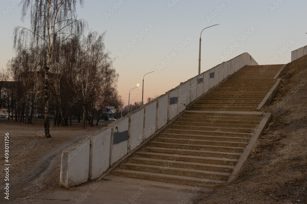 a staircase with many steps at dawn with the moon in the sky
