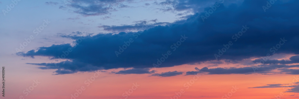 Beautiful sunset sky background with clouds and moon. Scenic cloudscape. Wide panoramic background for design.