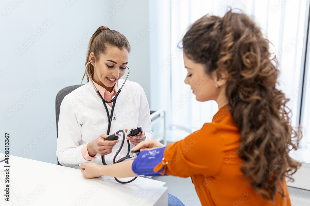 Nurse measuring blood pressure of a woman patient during an examination in the clinic. Doctor checking patient arterial blood pressure. Health care. Nurse measuring blood pressure of a woman patient during an examination in the clinic. Doctor checking patient arterial blood pressure. Health care.