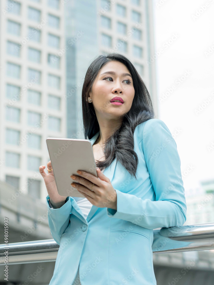 Beautiful cute girl business woman clothes holding a smart phone, urban city background Beautiful cute girl business woman clothes holding a smart phone, urban city background