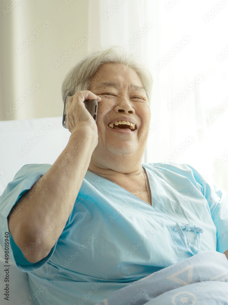Elderly patients in hospital bed patients using smart phone call to descendant relatives feel happy ness - medical and healthcare concept Elderly patients in hospital bed patients using smart phone call to descendant relatives feel happy ness - medical and healthcare concept