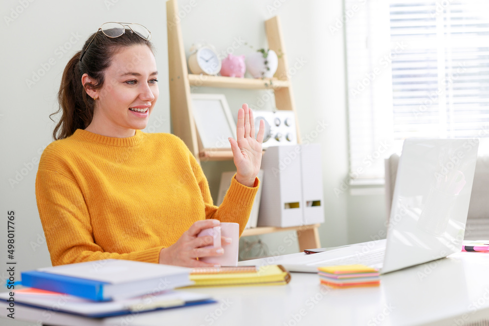 Young business woman is greeting her partner during making video conference Young business woman is greeting her partner during making video conference