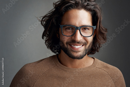 Frames that make a clear statement. Studio shot of a handsome young man wearing glasses against a gray background. photo