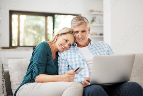 So...what are we buying today. Cropped shot of an affectionate mature couple using their laptop to do some online shopping at home.
