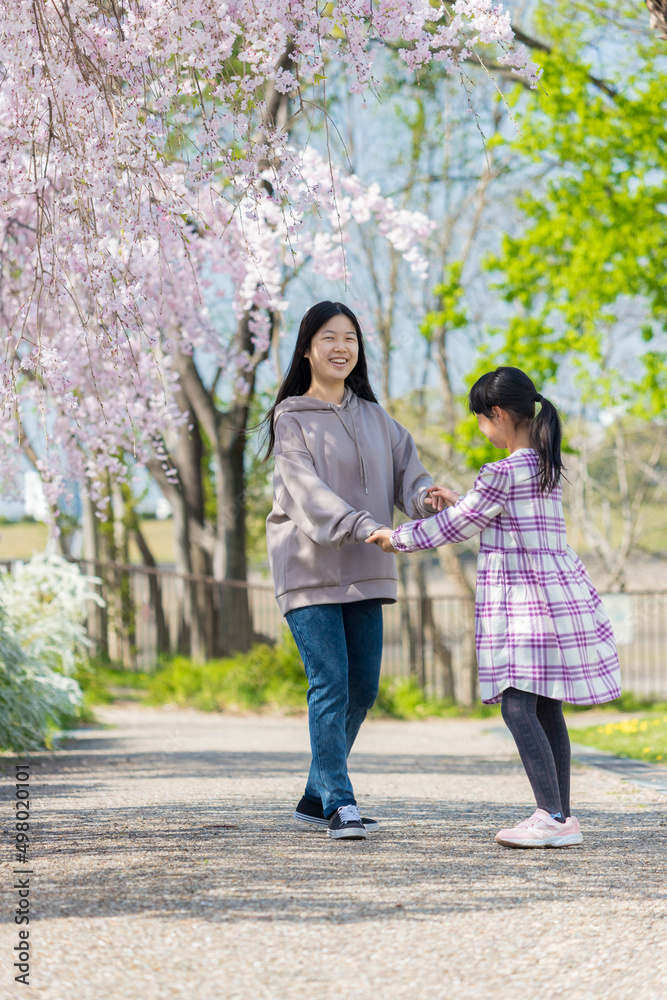 春の公園で遊んでいる子供姉妹の姿 春の公園で遊んでいる子供姉妹の姿