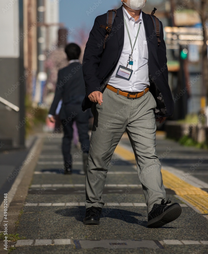 オフィス街で歩いている中年サラリーマンの姿 オフィス街で歩いている中年サラリーマンの姿