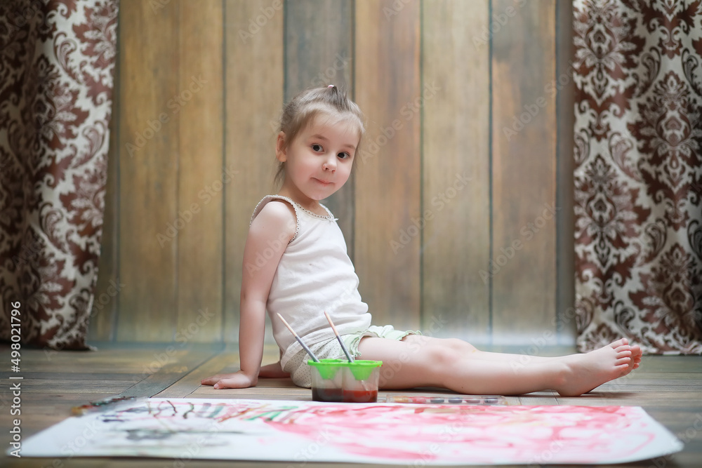 Little children paint on a large sheet of paper Little children paint on a large sheet of paper