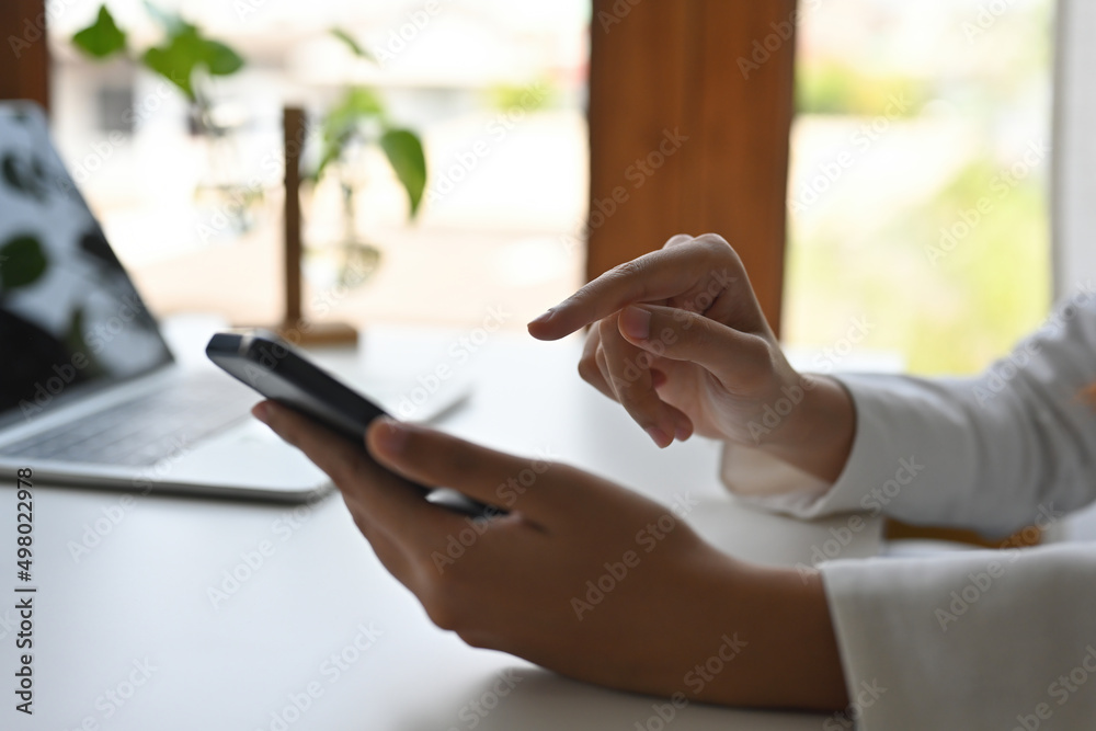 Side view close up of hands leaning to the table in the office holding a smartphone with pointing finger, for business and technology concept. Side view close up of hands leaning to the table in the office holding a smartphone with pointing finger, for business and technology concept.