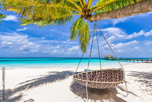 Tropical beach paradise as summer landscape with beach swing or hammock and white sand, calm sea for serene beach. Luxury beach scene vacation summer holiday. Exotic island nature travel destination