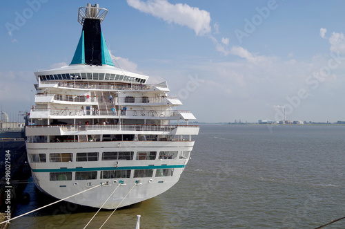 Classic cruiseship cruise ship liner Artania in Bremerhaven port with infrastructure, terminal and other ships on sunny day with blue sky and close up details of vessel superstructure and funnel photo