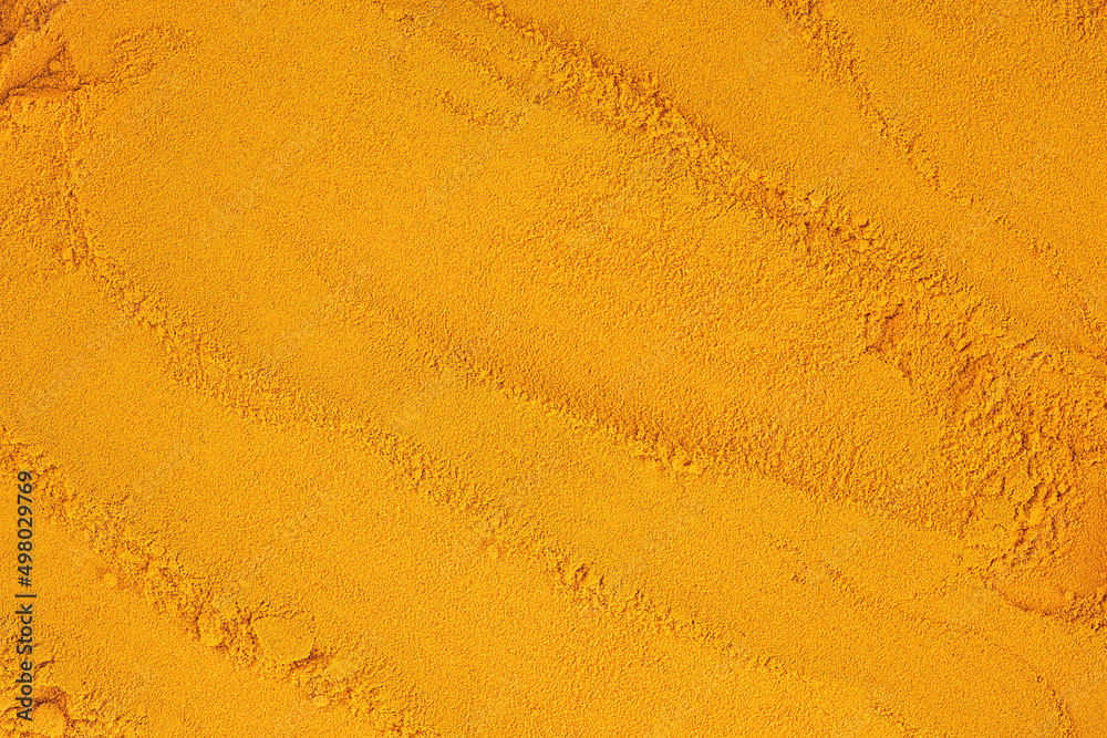 Turmeric powder pile as background and texture, top view. Turmeric powder pile as background and texture, top view.