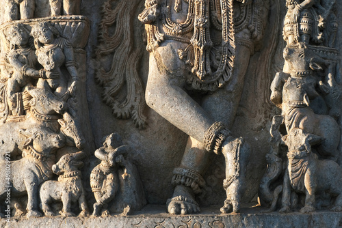 Stone Sculpture of Lord Krishna with selective focus, 12th century Hindu temple, Ancient stone art and sculptures in each pillars, Chennakeshava Temple, Belur, Karnataka, India. photo