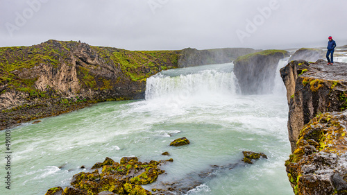 Scenic view of popular tourist attraction waterfall Godafoss in Iceland with tourists watching the sightseeing  summer  dramatic sky.