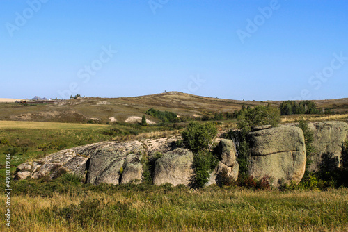 High stones on a background of the blue sky in sunny weather in the village of Savvushka, Altai Mountains, Siberia, Russia. Natural landscape