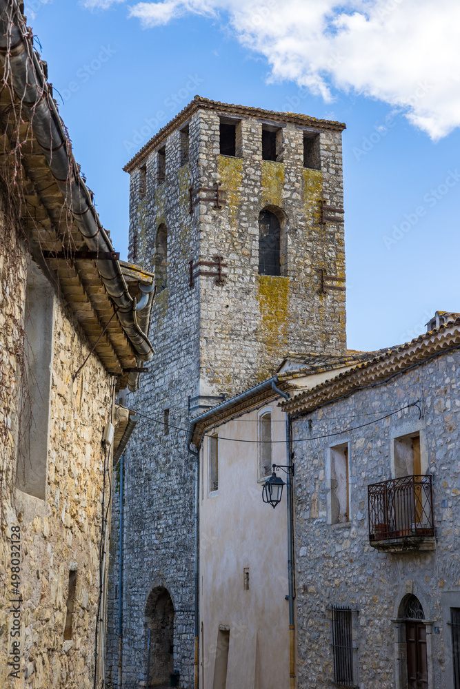 Clocher de l'Eglise Notre-Dame-de-l'Assomption depuis une ruelle du village médiéval des Matelles (Occitanie, France) Clocher de l'Eglise Notre-Dame-de-l'Assomption depuis une ruelle du village médiéval des Matelles (Occitanie, France)