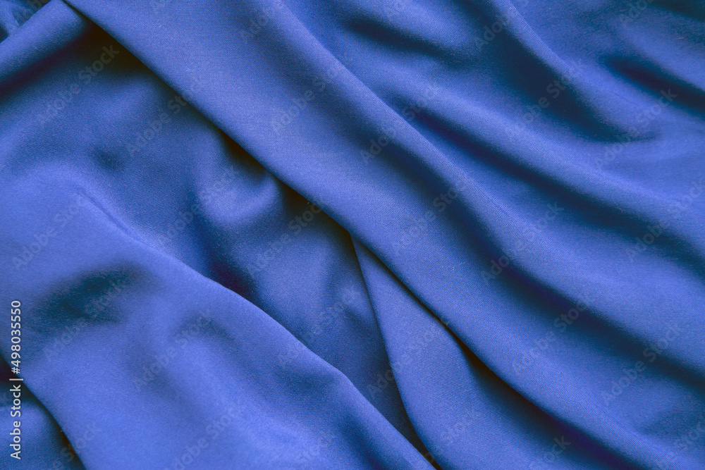 Background from blue fabric in folds. The texture of the fabric. Background from blue fabric in folds. The texture of the fabric.