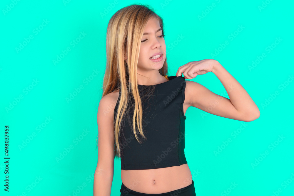 blonde little kid girl wearing black sport clothes over green background stressed, anxious, tired and frustrated, pulling shirt neck, looking frustrated with problem blonde little kid girl wearing black sport clothes over green background stressed, anxious, tired and frustrated, pulling shirt neck, looking frustrated with problem