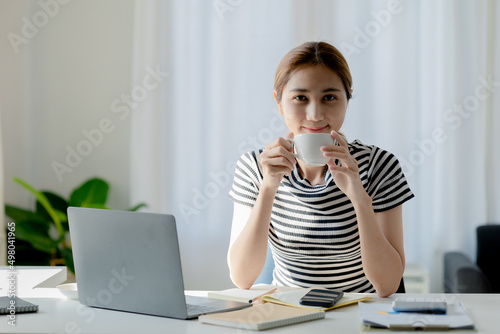 Asian woman drinking coffee after class makes me drowsy, she is a university student, The concept of online learning due to the COVID-19 outbreak to prevent an outbreak in the classroom. photo