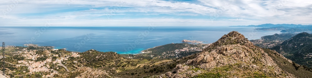 Panoramic view of the coastline of Corsica and the village of Corbara, Bodri beach the red rock of Ile Rousse with Cap Corse in the distance