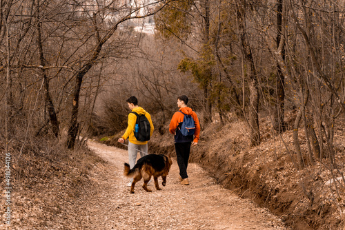 Fototapeta Naklejka Na Ścianę i Meble -  Walking their dog on the path in the forest together while enjoying their time