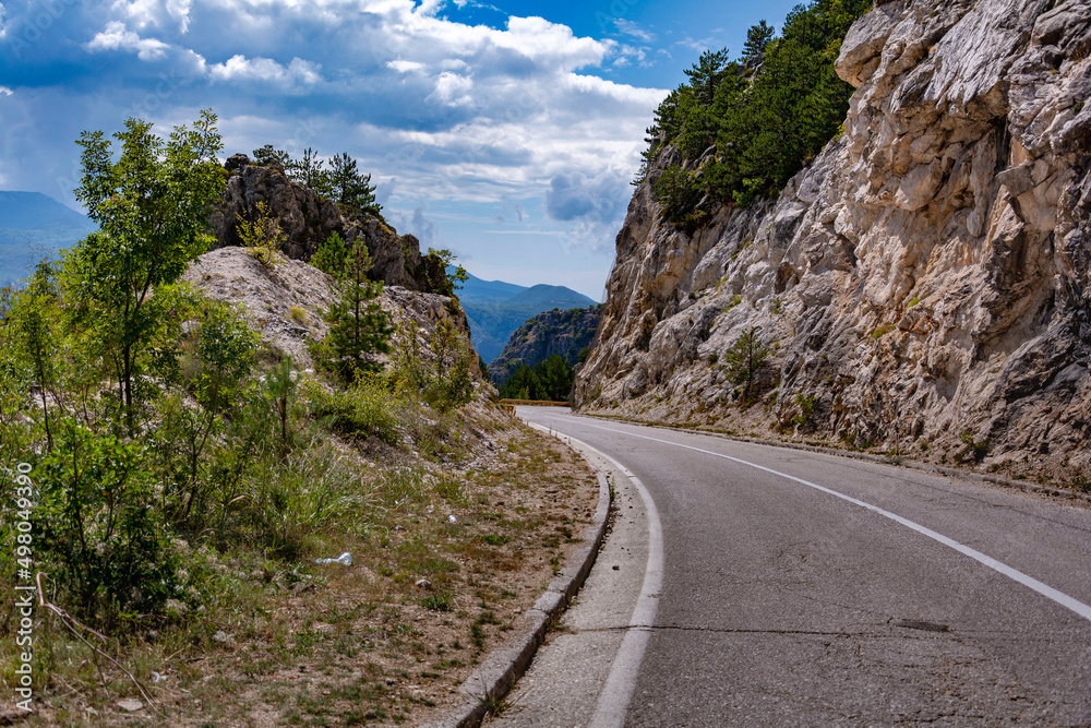 Fototapeta premium Empty mountain asphalt road in a sunny day at the mountains of Bosnia and Herzegovina