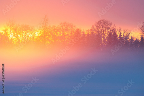 A wintry sunset with vibrant light reflecting on rising mist