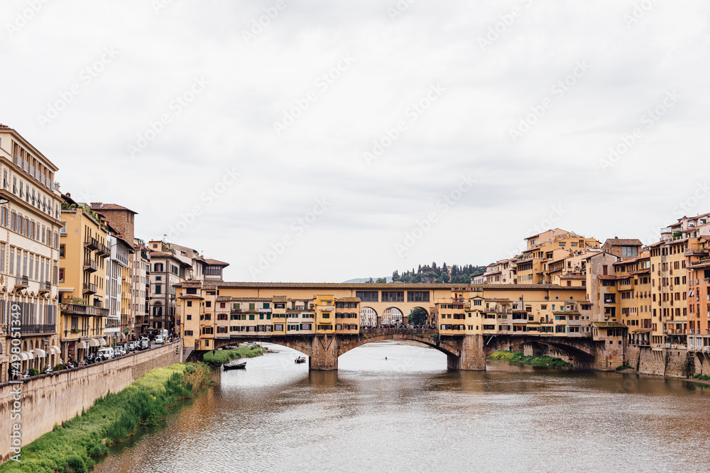 Florence famous Ponte Vecchio on the Arno river bridge Ponte alle Grazie on a cloudy day. Famous Italian landmarks