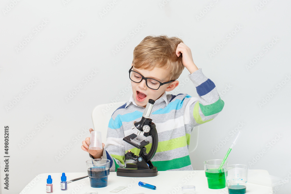 Boy five years old, experimenting with colored liquids. Chemical experiments of a little scientist boy of European appearance. Boy five years old, experimenting with colored liquids. Chemical experiments of a little scientist boy of European appearance.