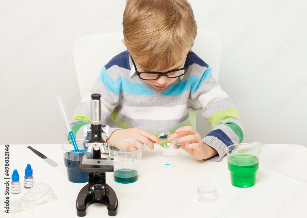 Boy five years old, experimenting with colored liquids. Chemical experiments of a little scientist boy of European appearance. Boy five years old, experimenting with colored liquids. Chemical experiments of a little scientist boy of European appearance.