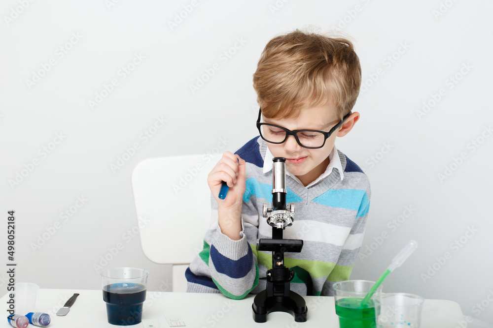 Boy five years old, experimenting with colored liquids. Chemical experiments of a little scientist boy of European appearance. Boy five years old, experimenting with colored liquids. Chemical experiments of a little scientist boy of European appearance.