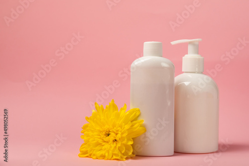 White bottles of cosmetic tonic and rinse gel on a pink background with shadow. foreground. Lotion  balm  gel  MOCKUP model from other manufacturers. pure beauty concept.